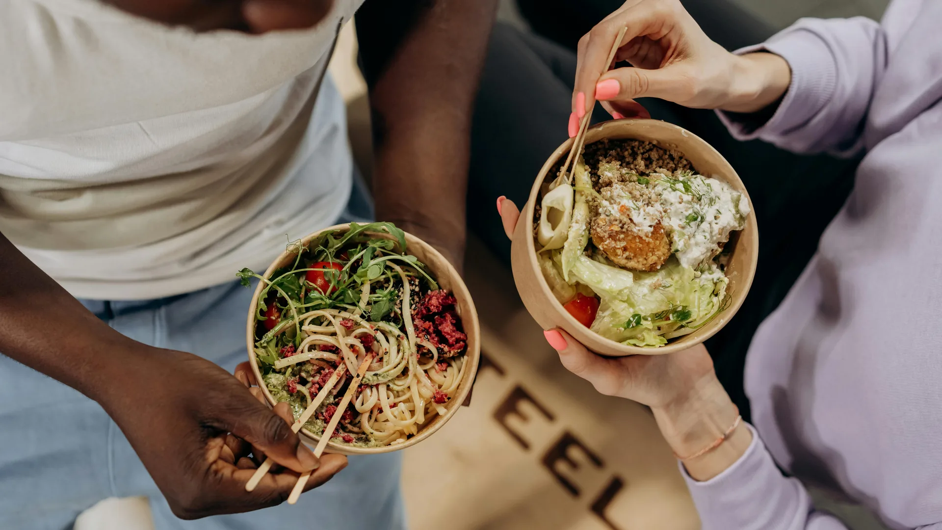 Two people eating fresh HealthyRizz meal bowls